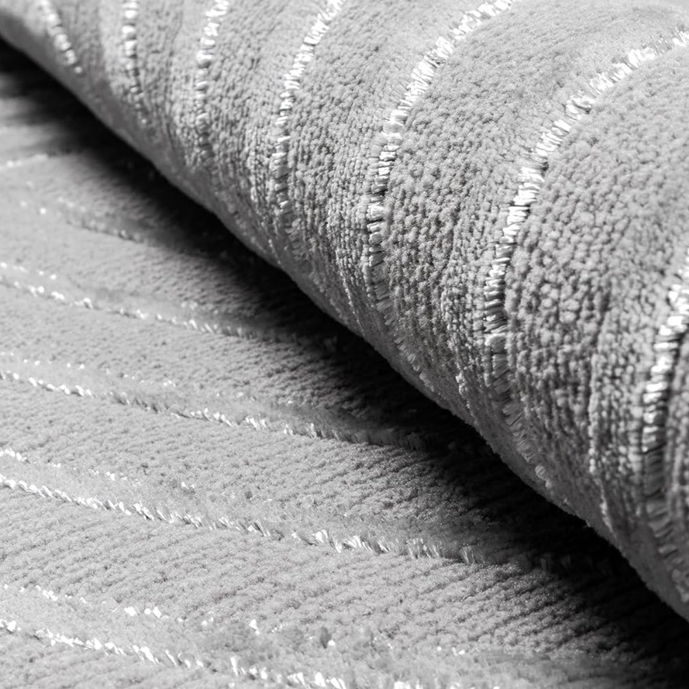Grauer Teppich mit gebogenen Linien und glänzenden Fäden